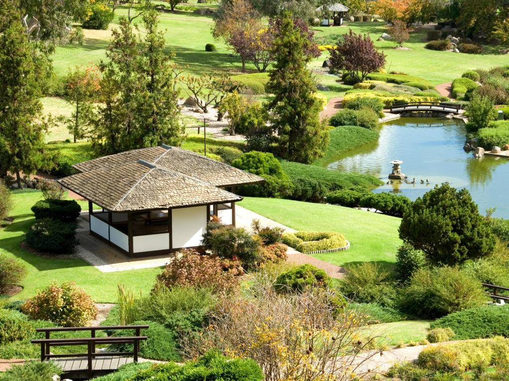 Beautiful manicured garden and pond with a small viewing hut facing the water