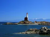 Beautiful lighthouse on a sunny day with mountains in the background in Victoria, Vancouver Island