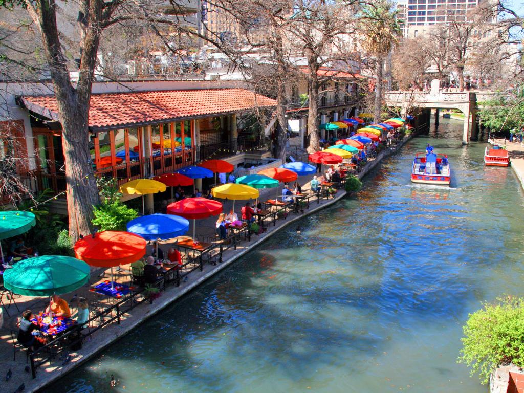 Famous River Walk in San Antonio with colorful umbrellas by the shore