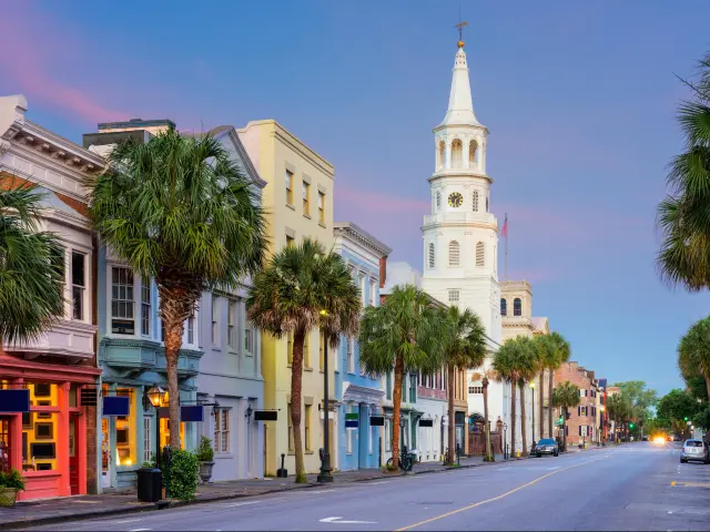 Charleston, South Carolina, USA with a row of colorful buildings and palms trees in the French Quarter taken at early evening.