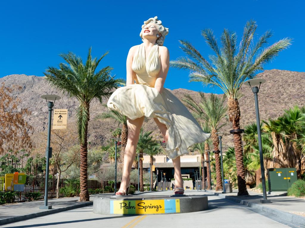 A giant Marilyn Monroe statue called "Forever Marilyn" in between the palm trees on a sunny day