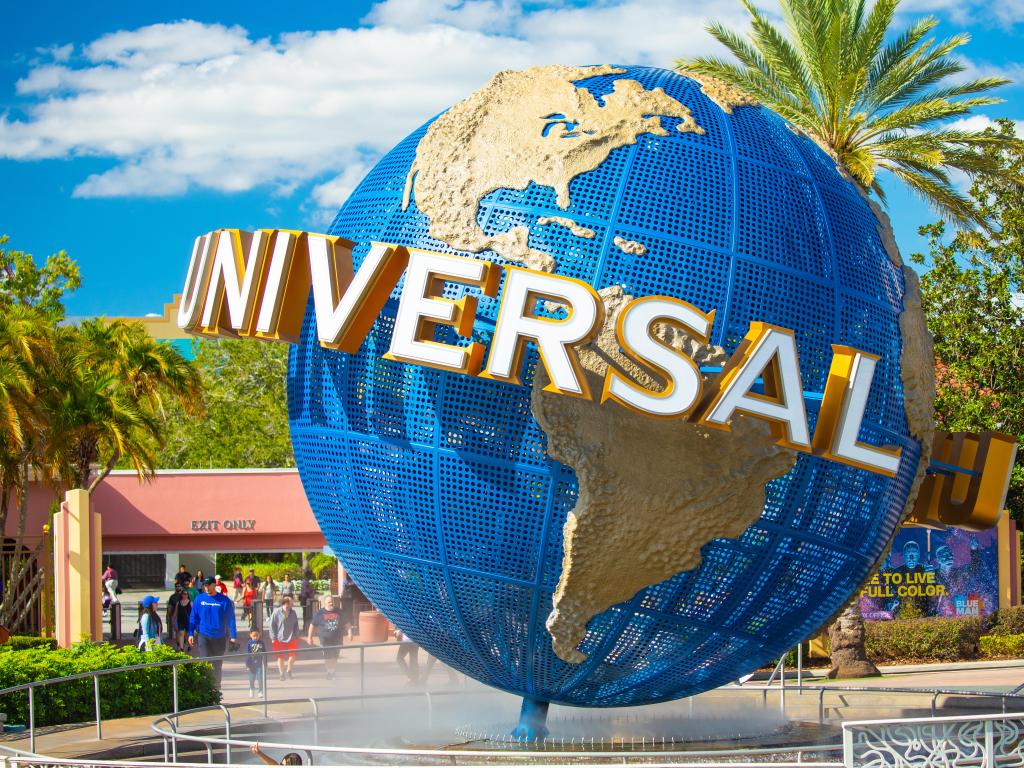 Orlando, Florida, USA with a view of the famous Universal Globe at Universal Studios Florida theme park on a sunny day with palm trees in the background.