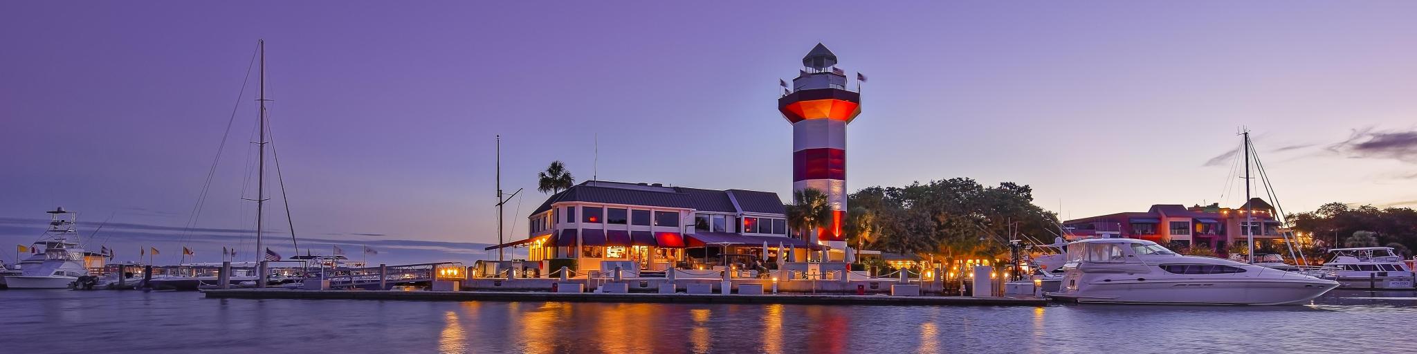 Dusk at downtown Hilton Head Island, with the iconic, historic lighthouse set against a purple sky