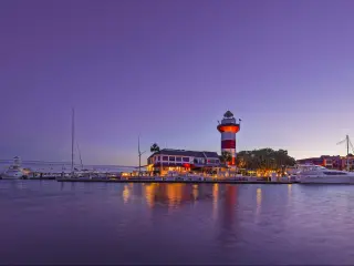 Dusk at downtown Hilton Head Island, with the iconic, historic lighthouse set against a purple sky