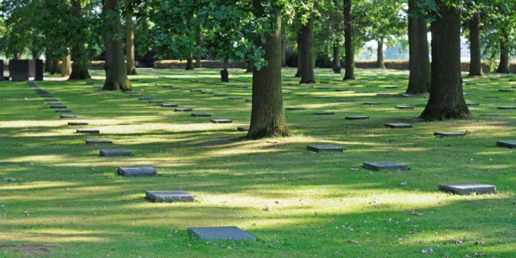 Rows of flat, black grave markers amidst the grass at Langemark German Cemetery, Ypres, Belgium