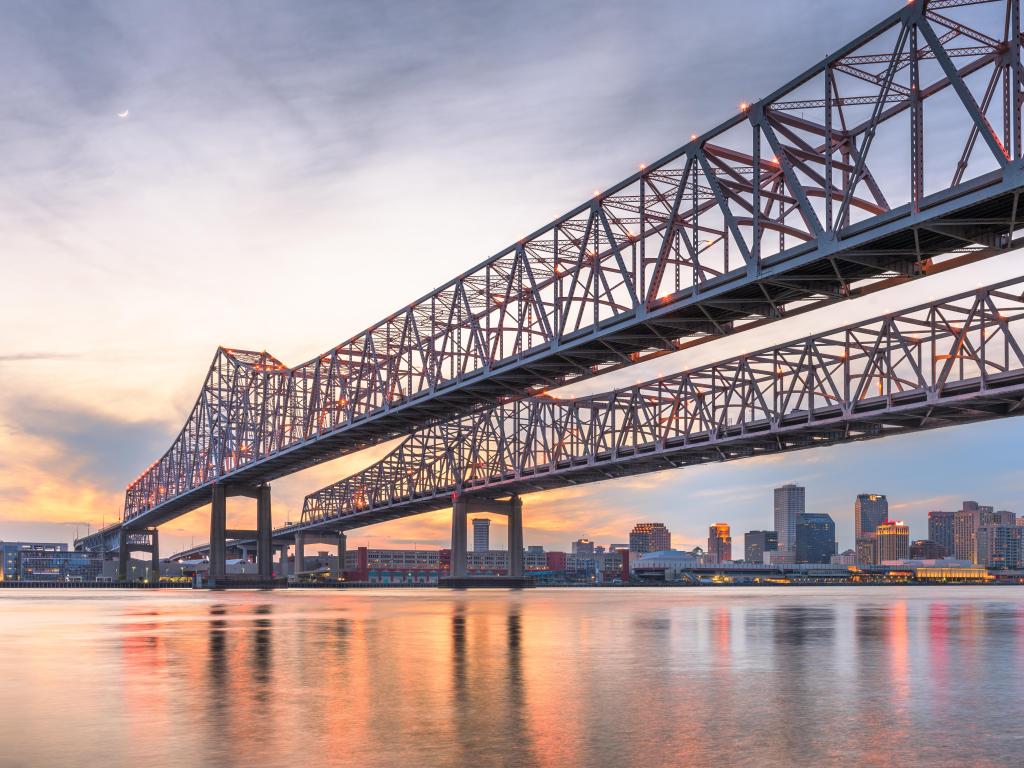 New Orleans, Louisiana, USA at Crescent City Connection Bridge over the Mississippi River at dusk.