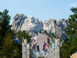 Entrance to Mount Rushmore surrounded with US flags and Mount Rushmore in the background, South Dakota