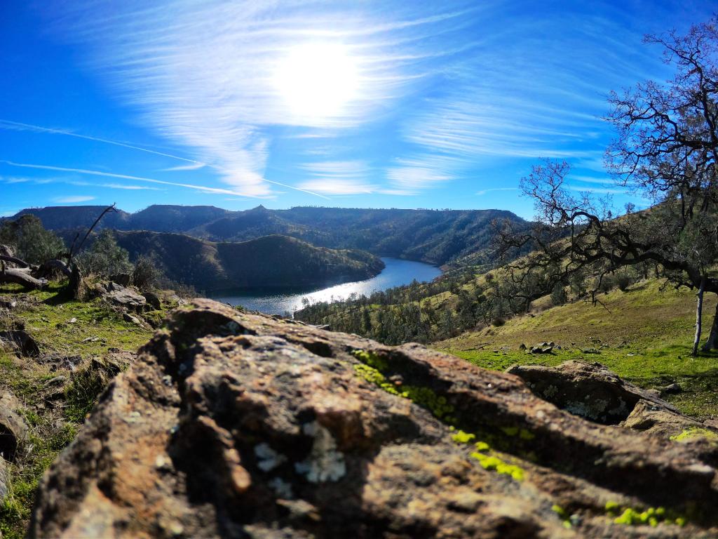 View of the San Joaquin River from the Fresno area in California on a sunny day, with rocks in the foreground