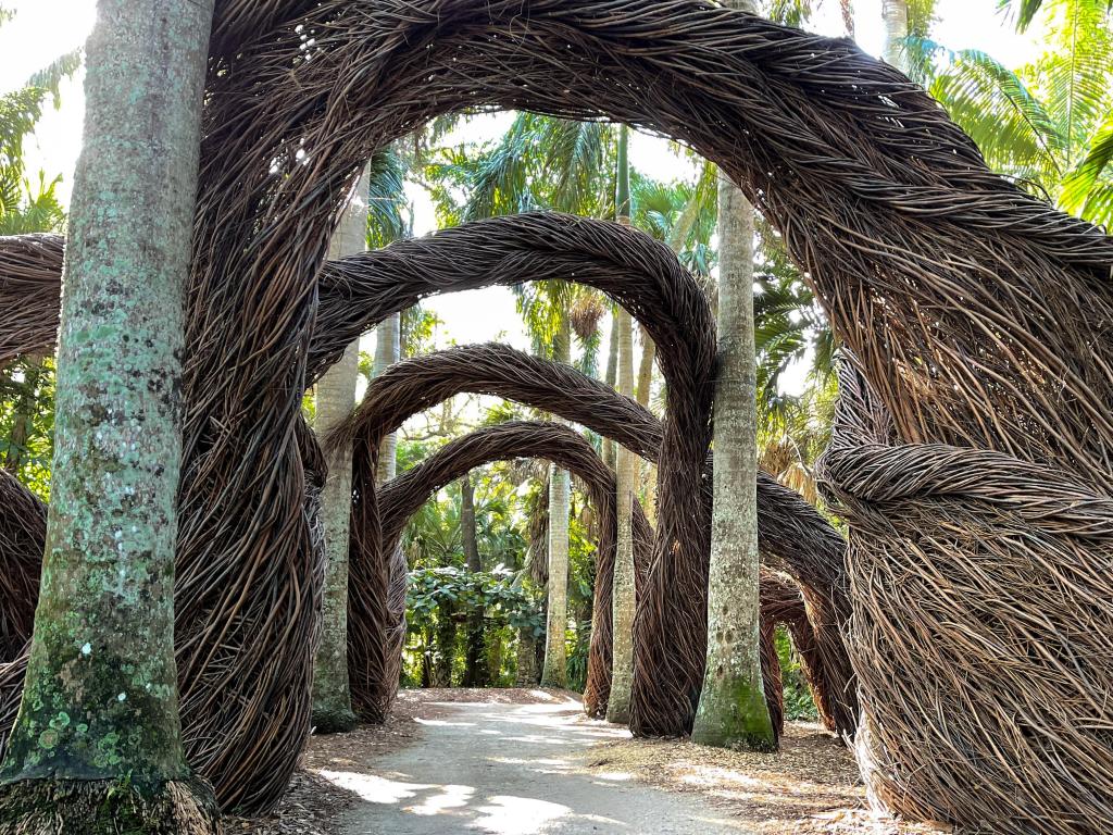 A landscaped walkway among archways made with tree twigs