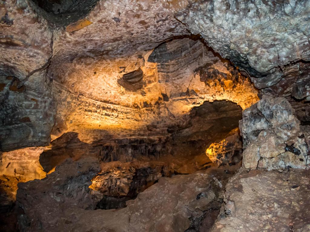 Wind Cave National Park, South Dakota taken inside the cave with geological formation of rocks lit up with a yellow glow. 