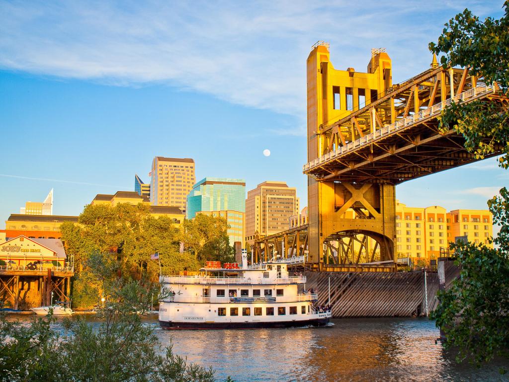 City skyline with river in front with vertical lift bridge and river cruise boat