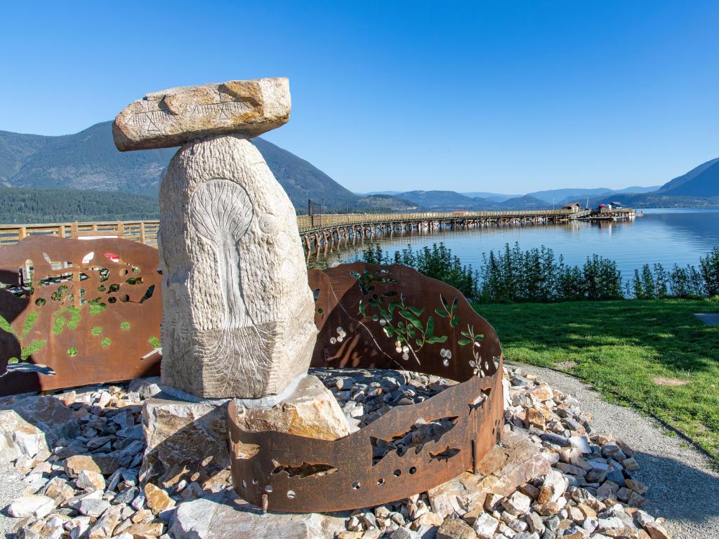 Close up image of the rock and metal Secwépemc Landmarks Sculpture, entrance to Salmon Arm wharf on a sunny day
