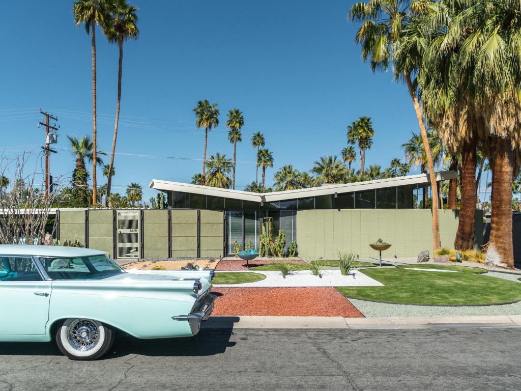 A vintage car parked outside a midcentury residential home in Palm Springs