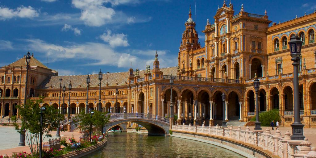 A bridge crosses the most in front of Plaza de Espana in Seville, Spain