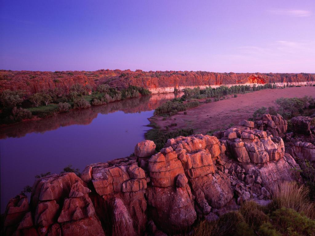 Geikie Gorge, Kimberley, Australia taken after sunset with rocks and cliffs and a river between the two.