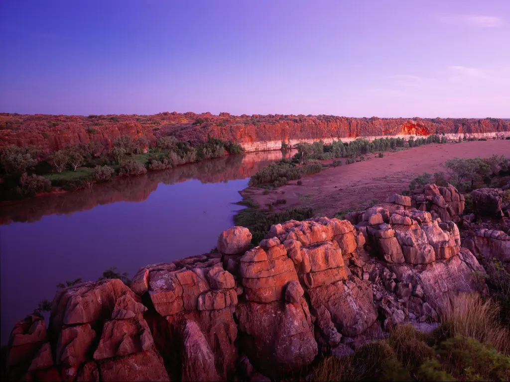 Geikie Gorge, Kimberley, Australia taken after sunset with rocks and cliffs and a river between the two.