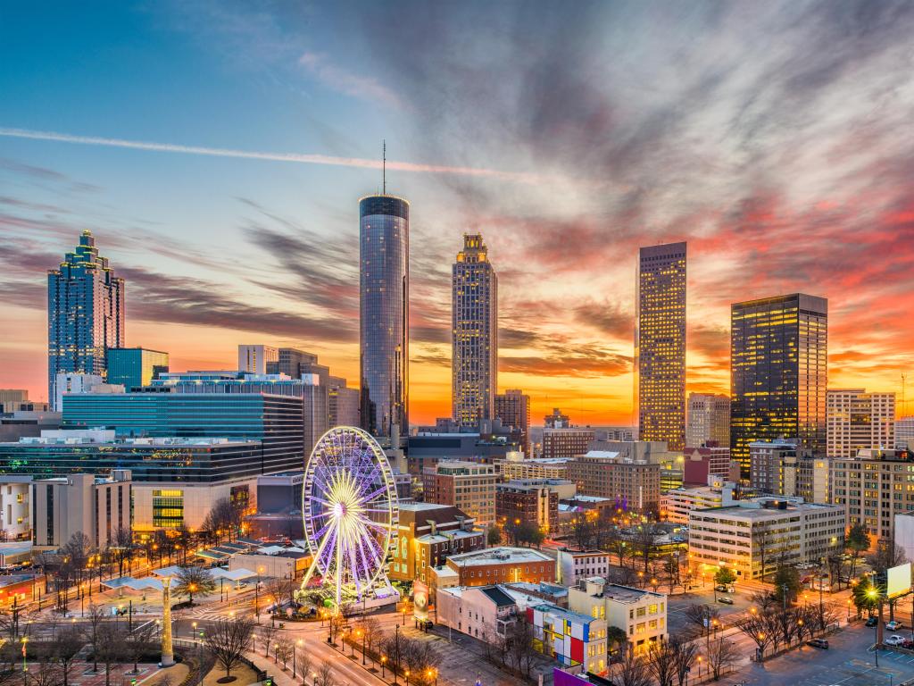 Skyline of Atlanta, Georgia, at sunset with high rise buildings in front of a colorful sky