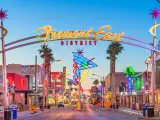 View of near empty Fremont East District at dawn, with bright neon lights and signs along both roadsides
