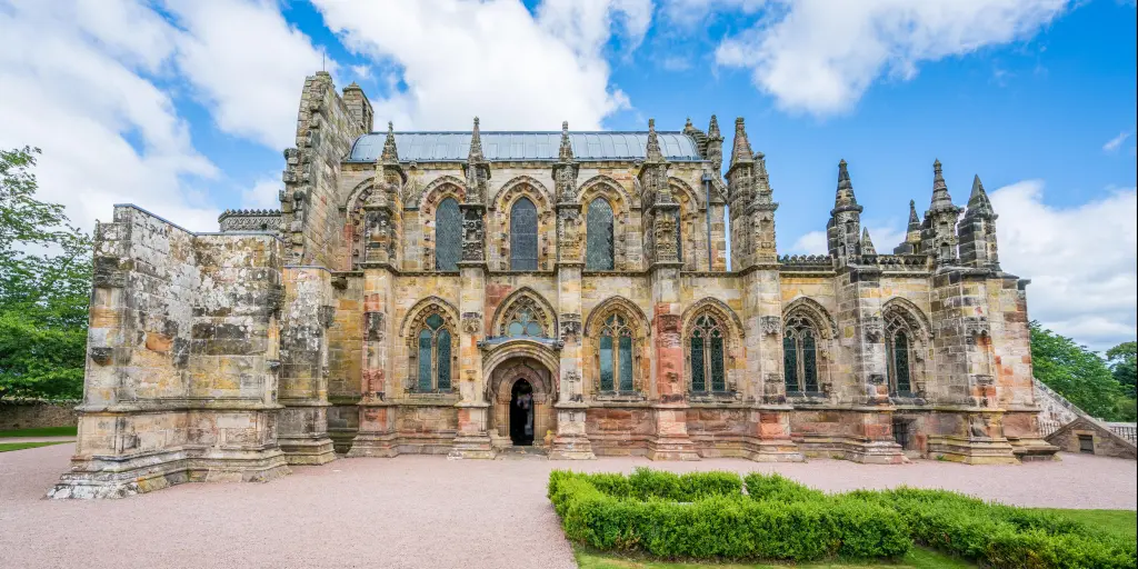 Rosslyn Chapel in the Scottish village of Roslin on a sunny day with blue sky and some clouds