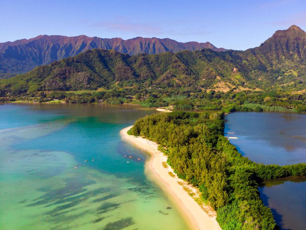 Aerial photo of Secret Island and Moli'i Pond at Kualoa Regional Park on Oahu, Hawaii, with clear water and rugged mountains
