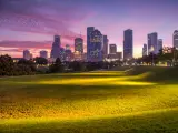Houston, Texas at sunrise with dawn twilight with green park lawn and the skyline in the distance.