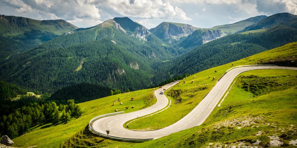 Winding Nockalm Road, Austria with green grass and cattle grazing 