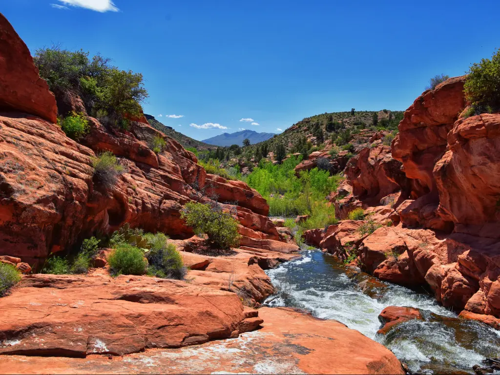 St George, Utah, USA with views of Waterfalls at Gunlock State Park Reservoir Falls, with a spring running off over desert erosion sandstone on a sunny day.