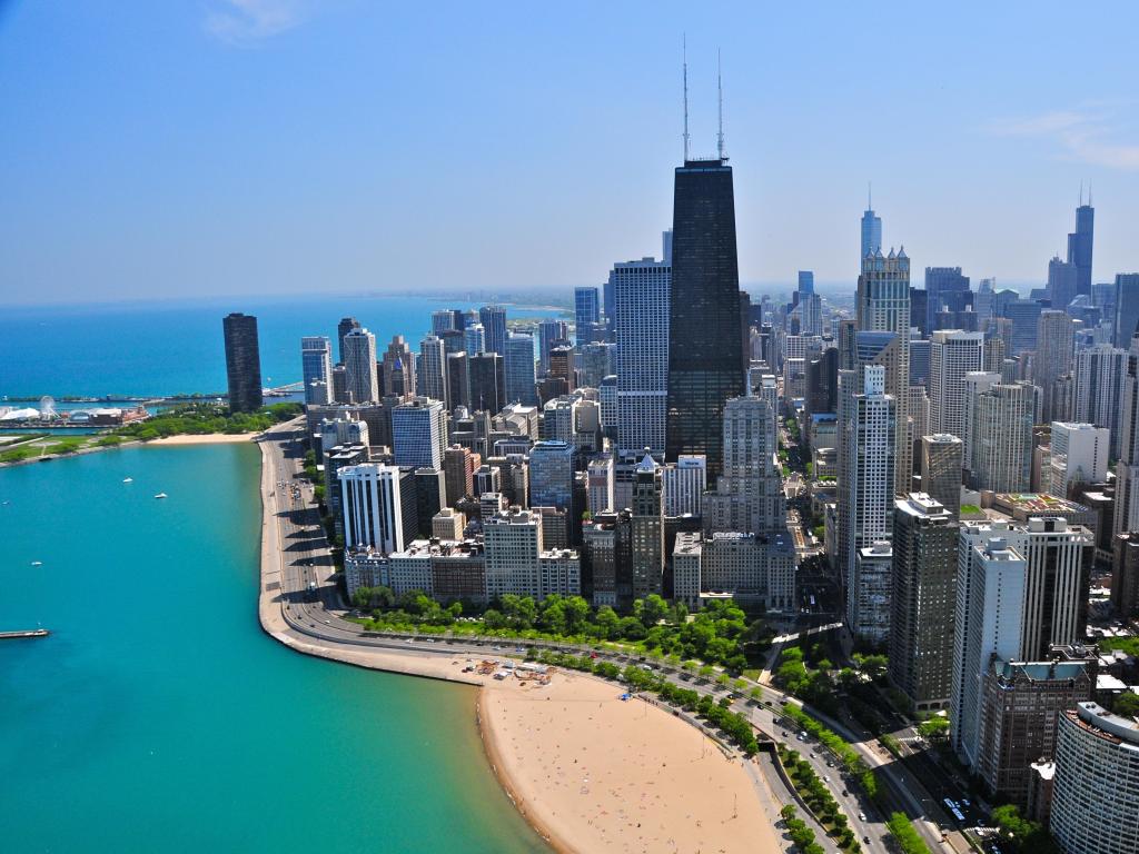 Sky scrapers beside blue lake with sandy beach, Chicago