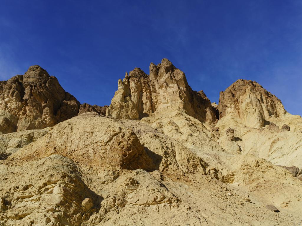 Golden Canyon, Death Valley National Park, California, USA with a view of the rock formations against a blue sky.