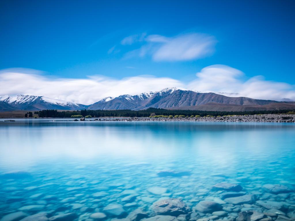 Crystal clear waters with mountains in the background at Lake Tekapo New Zealand