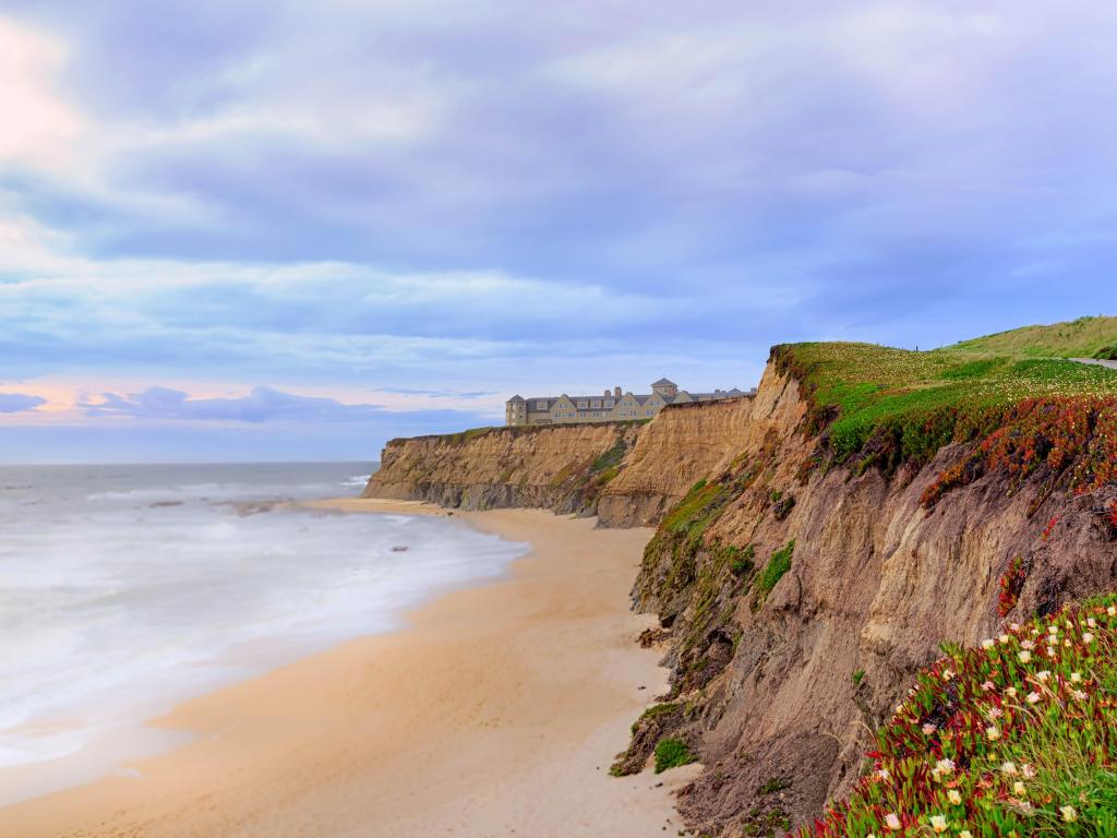Half Moon Bay, California, USA with the sand and cliffs on a cloudy soft haze day.