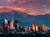 Los Angeles skyline at dusk with a purple sky and mountains behind the skyscrapers