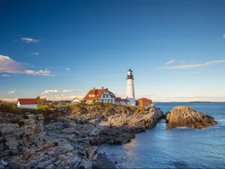 The Portland Head Light in Portland, Maine, USA, on a sunny day with blue skies.