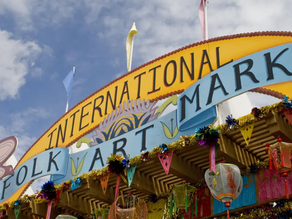 International Folk Art Market's sign with colorful lanterns hanging from the ceiling