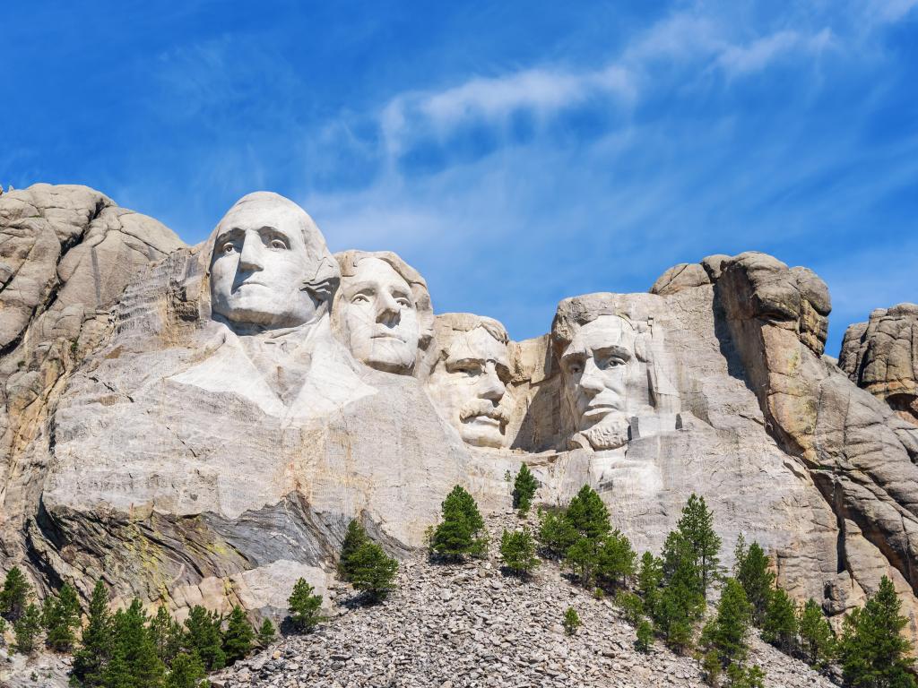 Presidential sculpture at Mount Rushmore national memorial, USA, on a sunny day with a blue sky.