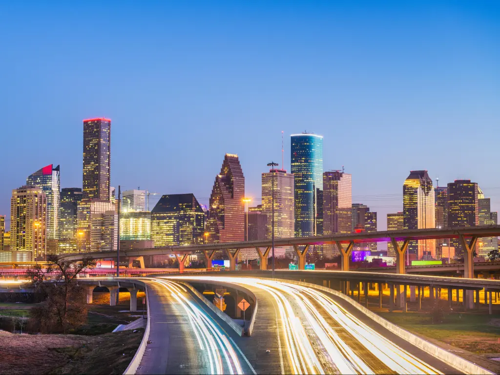 Houston, Texas, USA downtown city skyline and highway at dusk.