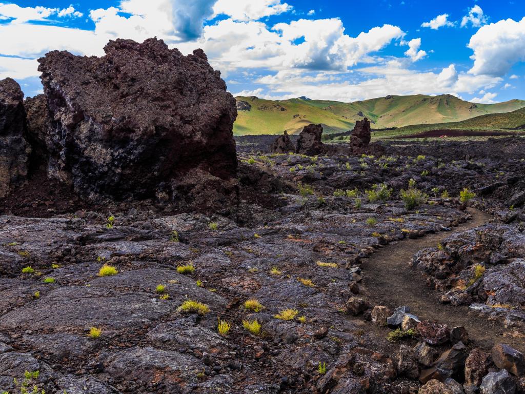 Craters of the Moon National Monument, Idaho, USA taken at North Crater Flows on a sunny day with a hills in the background.