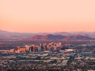 View of the city from above, with mountains rising in the background during sunset