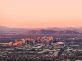 View of the city from above, with mountains rising in the background during sunset