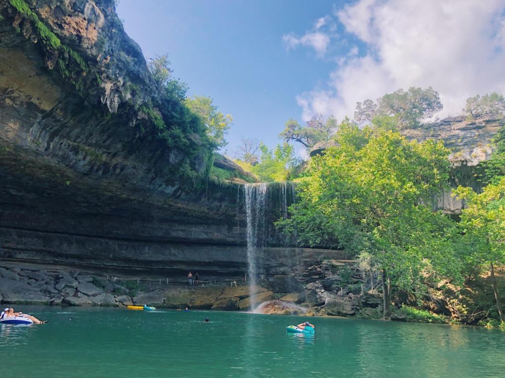 Swimmers enjoying the blue waters of Hamilton Pool in Dripping Springs, Texas