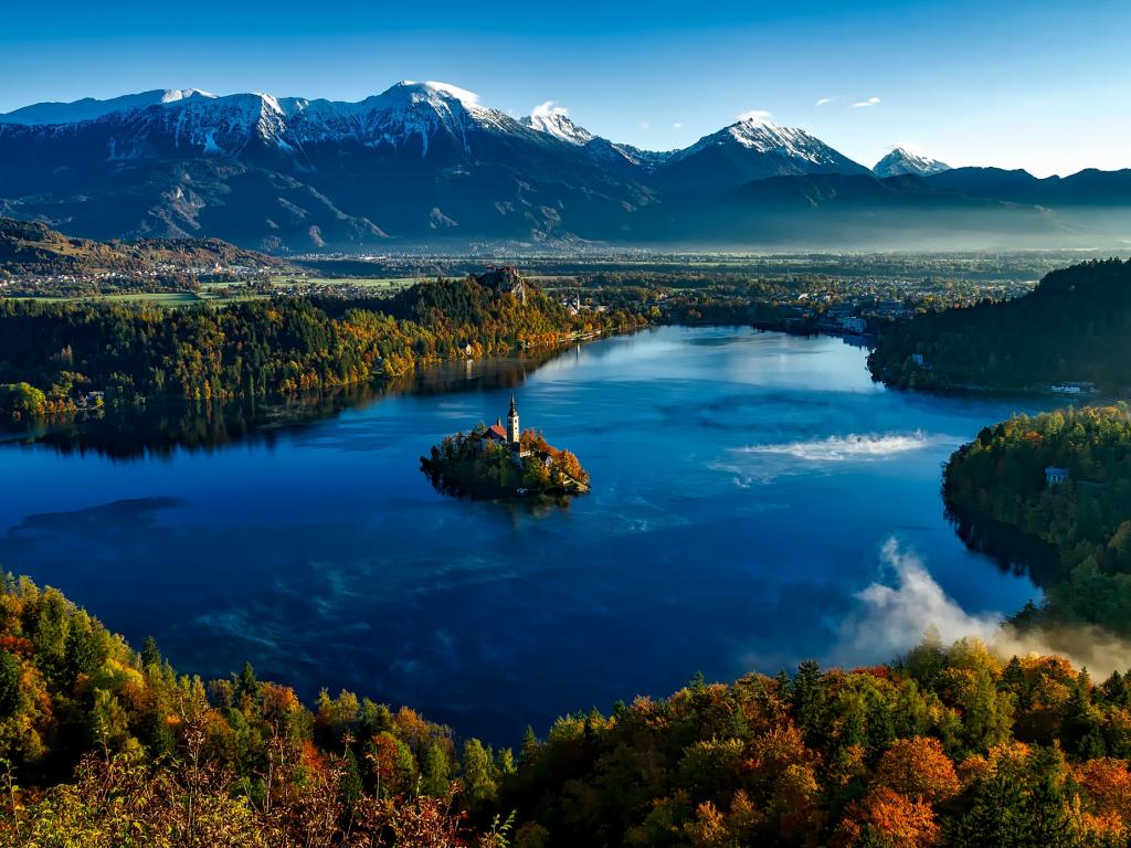 Bled Castle in the middle of Lake Bled is surrounded by colourful autumn leaves