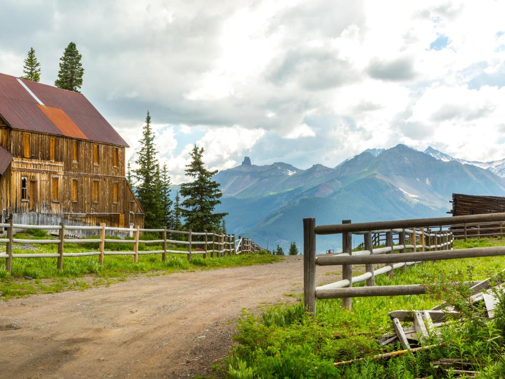 Deserted road going through Alta Ghost Town near Telluride, Colorado. Lizard Head Peak in the background surrounded by clouds