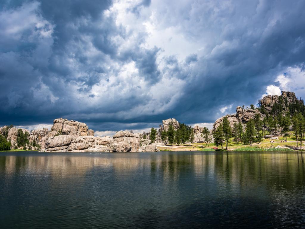 Custer State Park, South Dakota with storm clouds rolling in over Sylvan Lake, with the rock formations in the distance and trees. 