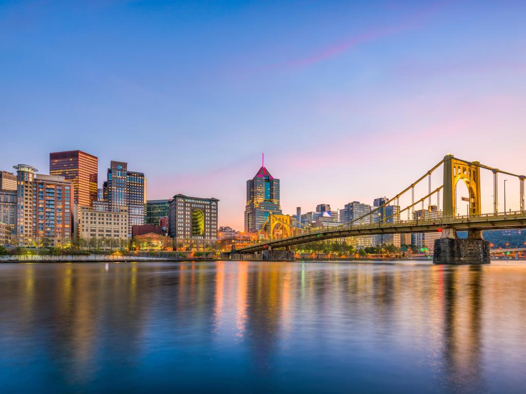 Pittsburgh, Pennsylvania, USA with the city skyline and bridge against the the river at early evening.