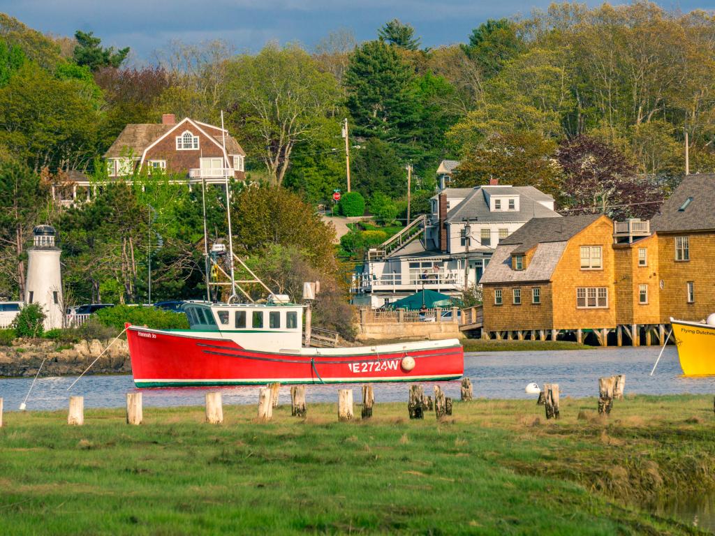 A red boat in the harbor at Kennebunkport, Maine, with trees in the background