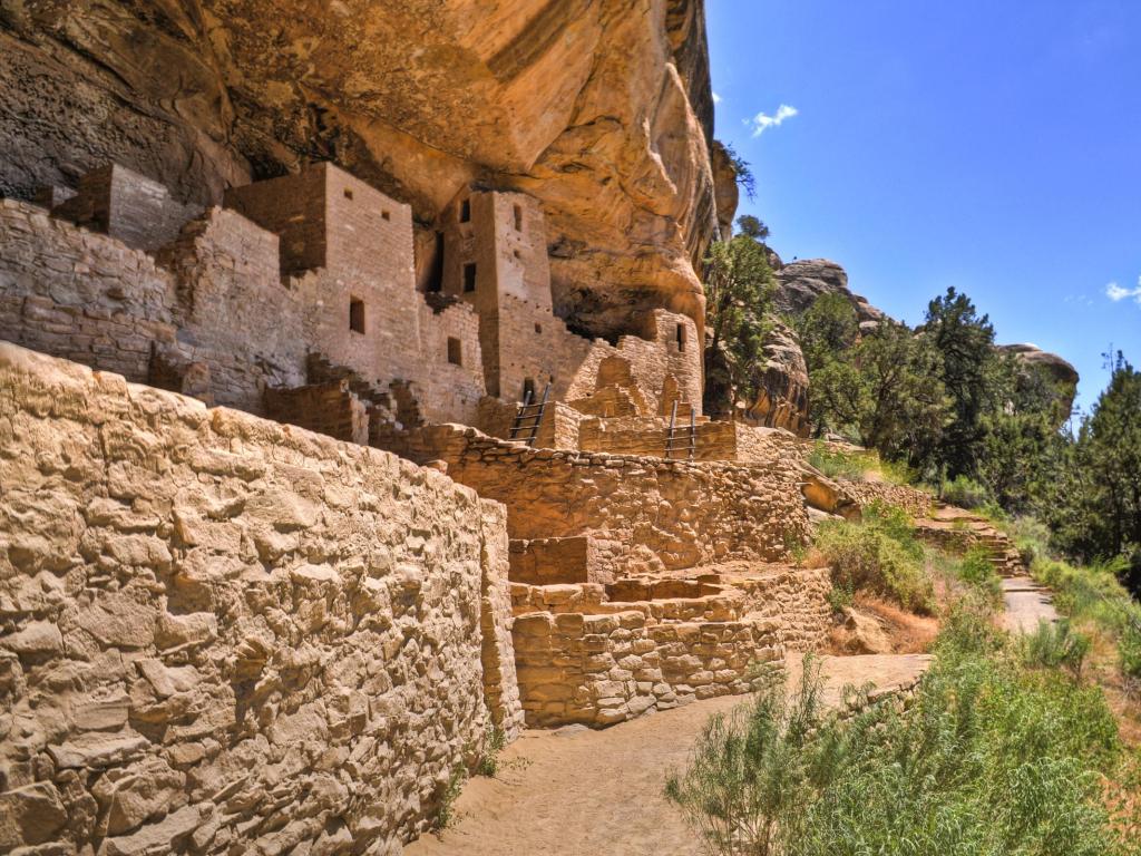Historic carved buildings at Cliff Palace in Mesa Verde National Park, with blue sky above