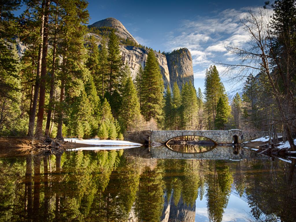 Stoneman bridge over the perfectly still Merced River in Yosemite National Park, California