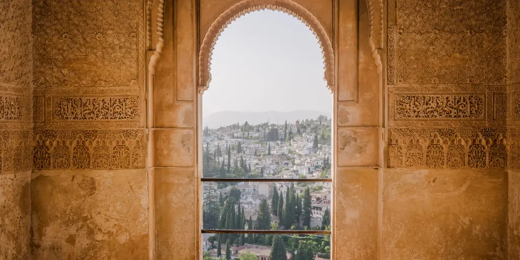 The rooftops and trees of Granada as seen through a Moorish door in the Alhambra fortress