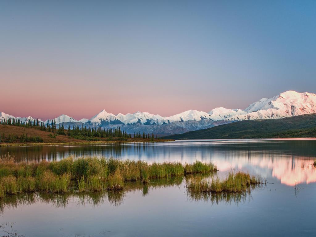 Mount Denali and clear water river surrounded by greenery