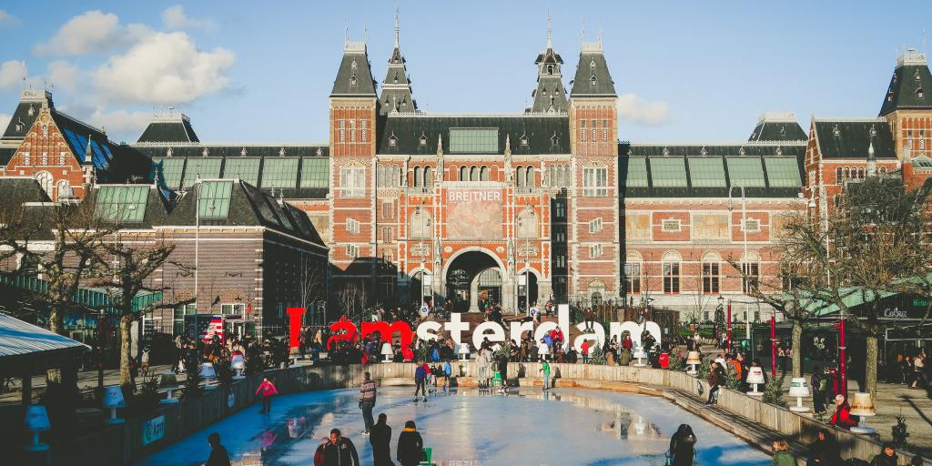 Shot of the Rijksmuseum and I Amsterdam sign with people ice skating 